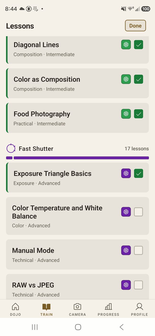 The Lessons list. Diagonal Lines, Color as Composition and Food Photography are ticked complete, then the Fast Shutter rank opens with seventeen lessons — Exposure Triangle Basics done, Color Temperature and White Balance, Manual Mode and RAW vs JPEG still to do.